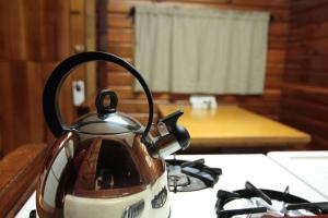 a tea kettle sitting on top of a stove at Miette Hot Springs Bungalows in Jasper