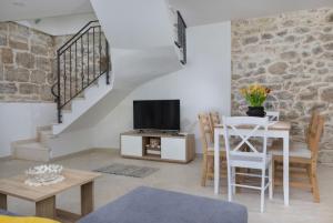 a living room with a tv and a table with chairs at Vila Eli in Brela