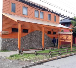 una mujer está parada frente a un edificio en Cabañas Ancestros en Coyhaique