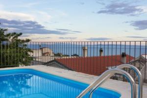 a swimming pool with a view of the ocean at Vila Eli in Brela