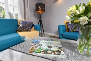 a living room with a table with a book and a vase of flowers at Hopton Cottage - Darwin Lake Holiday Village in Matlock +1 photo