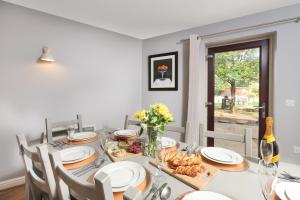 a dining room with a table with food and a window at Hopton Cottage - Darwin Lake Holiday Village in Matlock
