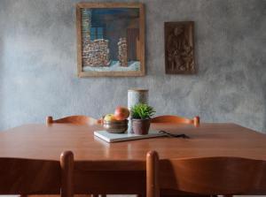 - une table en bois avec un bol de fruits et une plante dans l'établissement Maison Mey - CIR VDA GIGNOD 008, à Aoste