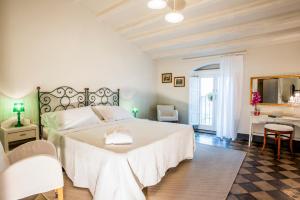a bedroom with a large white bed and a desk at Palazzo Degli Antoci in Ragusa