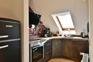 cocina con nevera negra y ventana en Fewo Blumes Bergfrieden mit MeineCardPlus, en Willingen