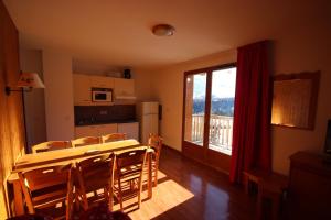 a kitchen and dining room with a table and chairs at Residence Le Hameau du Puy by Actisource in Le Dévoluy