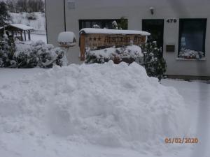una pila de nieve frente a un edificio en Apartman Aya, en Janov nad Nisou
