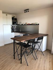 een keuken met een houten tafel en 4 stoelen bij Le Boucanier in Vieux-Boucau-les-Bains