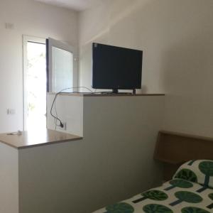 1 dormitorio con TV de pantalla plana en la pared en Agriturismo Cà Mignone, en Urbino