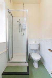 a bathroom with a shower and a toilet at Old Trafford Stadium Hotel in Manchester