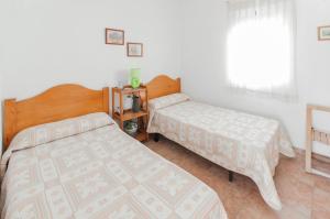 a bedroom with two beds and a window at Tallarol in Playa de Gandia