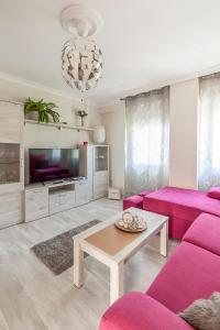 a living room with a pink couch and a table at Fantastico apto recién 2 hab-Sevilla-Triana in Seville