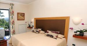 a bedroom with a bed with a large headboard at Quinta Da Cova Do Milho in Santo da Serra