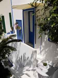 una puerta azul en un edificio blanco con plantas en La Porta Blu, en Teulada