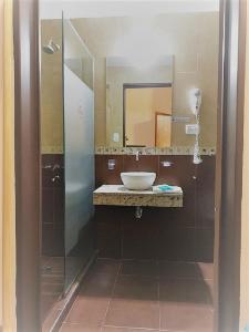 ein Bad mit einem Waschbecken und einem Spiegel in der Unterkunft Hostería Boutique El Puente Adults Only in Merlo