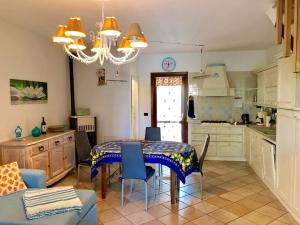 a kitchen with a table and chairs in a kitchen at Villetta Il Corallo in San Teodoro