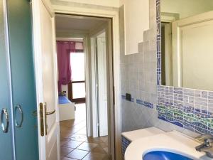 a bathroom with a sink and a mirror at Villetta Il Corallo in San Teodoro