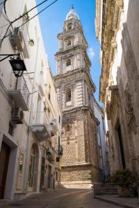 a tall building with a clock tower in a street at Palazzo Mulini in Monopoli