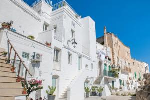 a white building with stairs and potted plants at Palazzo Mulini in Monopoli