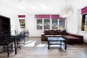 a living room with a couch and a table and chairs at Riu D'Incles in Incles