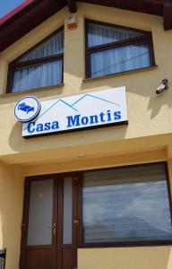 een bord aan de zijkant van een Casa Mountains gebouw bij CASA MONTIS in Borşa