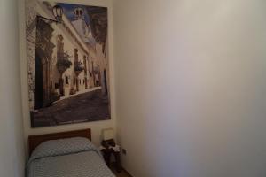 um quarto com uma cama e uma fotografia na parede em La Casa Del Nonno em Alberobello