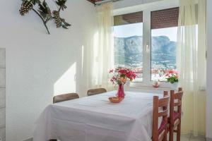 a dining room table with a vase of flowers on it at Apartment Josip in Omiš
