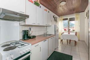 a kitchen with white cabinets and a white stove top oven at Apartment Josip in Omiš