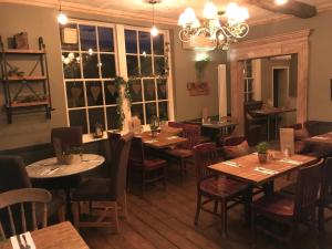 a restaurant with wooden tables and chairs and a chandelier at Galtres Lodge Hotel & Forest Restaurant in York