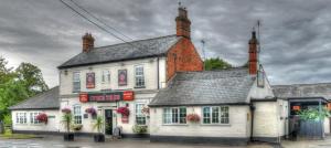 a white and red building with a restaurant at The Fordham Inn in Sharnbrook