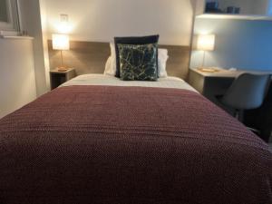 a bedroom with a bed with a red bedspread and two lamps at PS APARTMENTS in Southampton