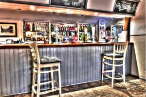 a bar with two chairs and a counter with drinks at The Fordham Inn in Sharnbrook