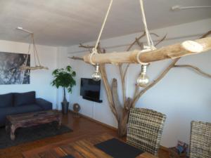 ein Wohnzimmer mit einem Baum und einer blauen Couch in der Unterkunft Holzmichel FEWO mit Balkon in Cottbus
