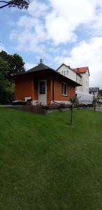 a house in a yard with a green lawn at Domek SERCE KRYNICY in Krynica Morska