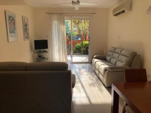 uma sala de estar com dois sofás e uma televisão e um sofá em Exceptional townhouse em Pafos