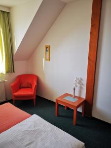 a hotel room with a bed and a chair and a table at Penzión Helios in Bratislava