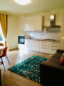 a kitchen with white cabinets and a green rug on the floor at RESIDENZA ELENA in Rimini