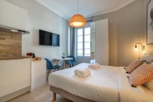 een slaapkamer met een bed met handdoeken erop bij Agences des Résidences - Rue Commandant André in Cannes