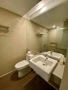 a bathroom with a white toilet and a sink at Kojõ Hotel Tagum in Tagum