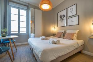 een slaapkamer met een groot bed en handdoeken bij Agences des Résidences - Rue Commandant André in Cannes