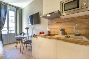 a kitchen with a sink and a counter with a table at Agences des Résidences - Rue Commandant André in Cannes