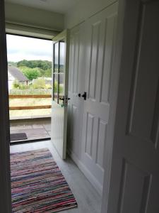 una puerta abierta con vistas a un porche en The Milk Barn, en Ashbourne