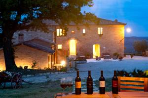 阿夏诺Agriturismo Mocine的木桌上放着一组葡萄酒瓶和玻璃杯