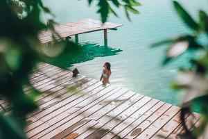 a woman standing on a dock in the water at Hotel Awazul Bacalar in Bacalar