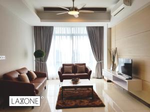 Una sala de estar con un sofá y un televisor. en Sutera Avenue Kota Kinabalu By LAXZONE, en Sembulan