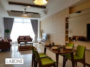 a living room with a table and green chairs at Sutera Avenue Kota Kinabalu - Laxzone Suite in Kampong Sembulan