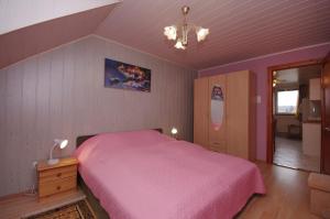 a bedroom with a pink bed in a room at Fortuna Apartman in Gyula