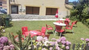 um grupo de cadeiras vermelhas e uma mesa num quintal em Apartamento el Peral A em Colombres
