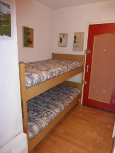 two bunk beds in a room with a red door at GAUDISSARD A612 in Barcelonnette