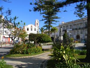 a street with a building and a park with a bench at Appartement Tavira in Tavira